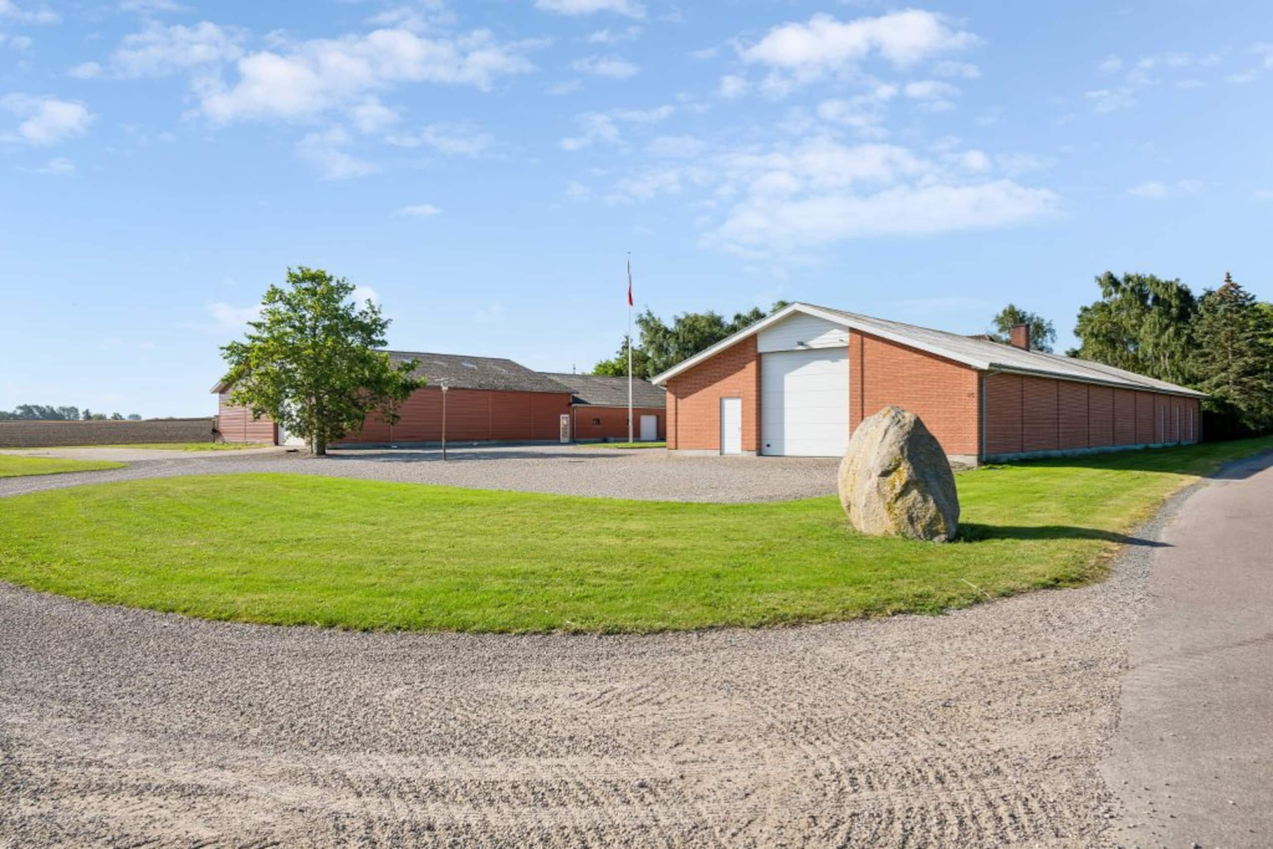 Avlsbygninger og padelhal set fra gårdspladsen