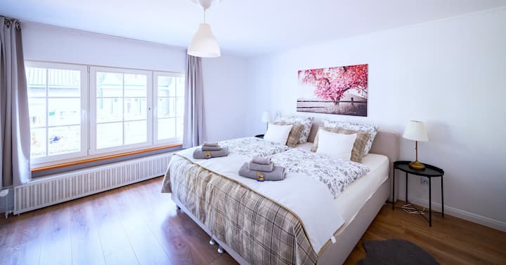 Vysnívané útočisko – priestranná posteľ s kvalitnou posteľnou bielizňou vás pozýva stráviť relaxačné noci. Veľkými oknami prúdi jemné denné svetlo, zatiaľ čo jemné farby a teplé akcenty vytvárajú uvoľnenú atmosféru.