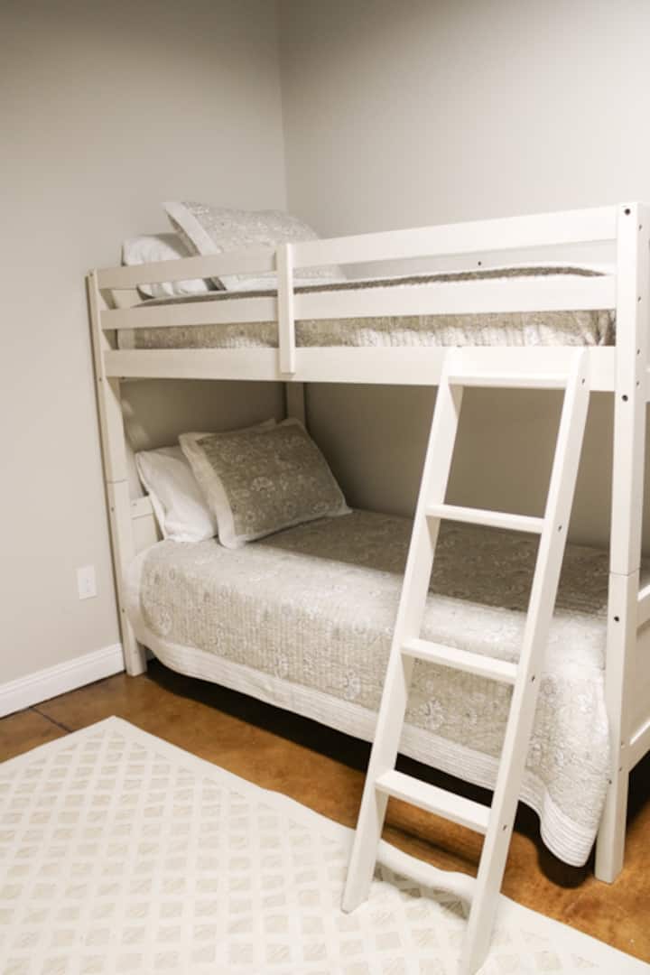 เตียงแฝดในห้องโถงชั้นใต้ดิน หมายเหตุ: ที่พักนี้เป็นพื้นที่เปิดโล่งที่ไม่มีประตู 