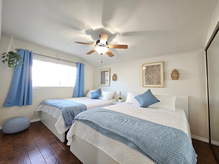 Relájate con estilo en este dormitorio sereno, con dos lujosas camas tamaño queen. El blues suave y los blancos te harán sentir como si estuvieras a pocos pasos de la orilla