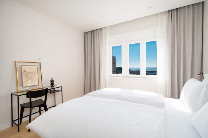 Malý pracovný stôl, zatemňovacie rolety a závesy. 