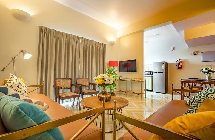 Spacious and inviting living area in our Goa villa, featuring comfortable seating, a dining space, and a well-equipped kitchenette for your convenience.