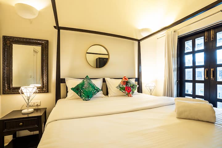 Rest in comfort in this charming bedroom at our Goa villa, featuring a stylish four-poster bed, tropical accents, and all the amenities for a peaceful night's sleep.