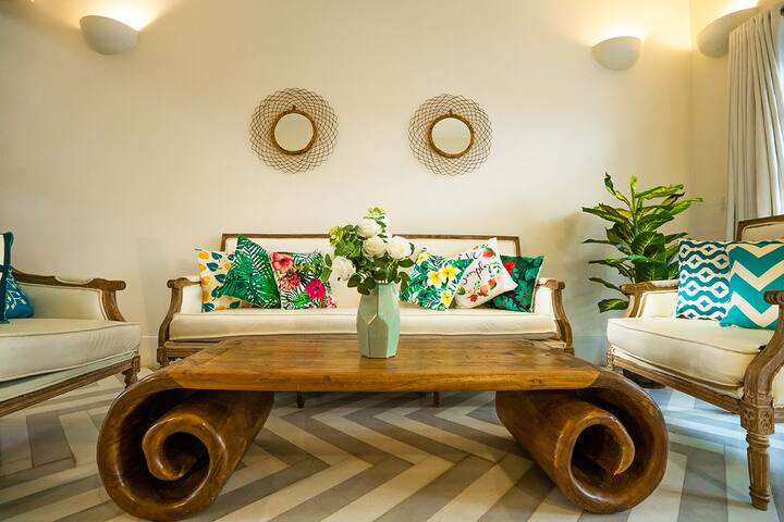 Step into the vibrant living room of our Goa villa, featuring a unique coffee table, tropical accents, and cosy seating for ultimate relaxation.