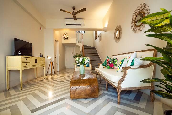 Charming living room in our Goa villa, featuring unique chevron flooring, comfortable seating, and vibrant décor, perfect for relaxing after a day of exploring.