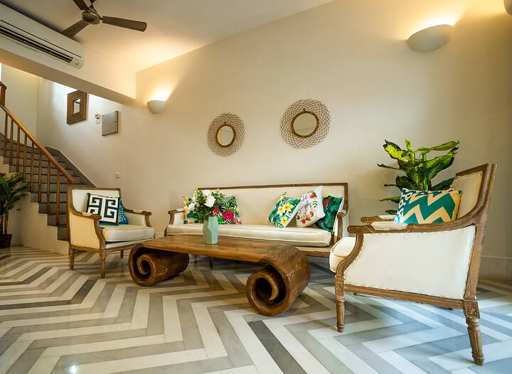 Inviting living area in our Goa villa, featuring stylish seating, unique chevron floors, and vibrant accents, perfect for relaxation and memorable moments.