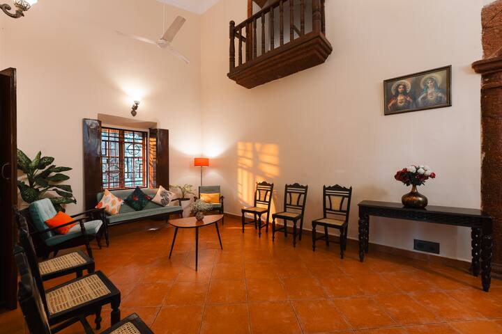 Step into the spacious living area of our Goa villa, featuring traditional charm, comfortable seating, and unique architectural details. Perfect for relaxing.