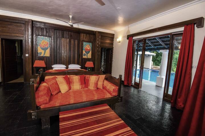 Indulge in vibrant comfort at our 5BHK Luxury Villa in Goa. This spacious bedroom offers direct pool access and lush views for an unforgettable tropical escape.