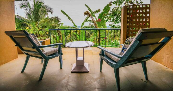 Relax on your private balcony at this 5BHK Luxury Villa in Goa. Enjoy lush green views and a peaceful setting, perfect for unwinding.