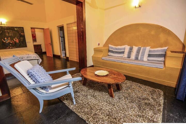 Cosy and artistic living space in our 5BHK Luxury Villa in Goa. Relax on the built-in sofa or armchair with unique décor.