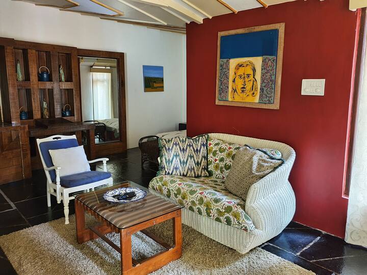 Experience a blend of vintage charm and modern comfort in this spacious living room. The vibrant floral mural and high ceilings open to a balcony, making it the perfect spot to unwind at our 6BHK Luxury Villa in Goa.