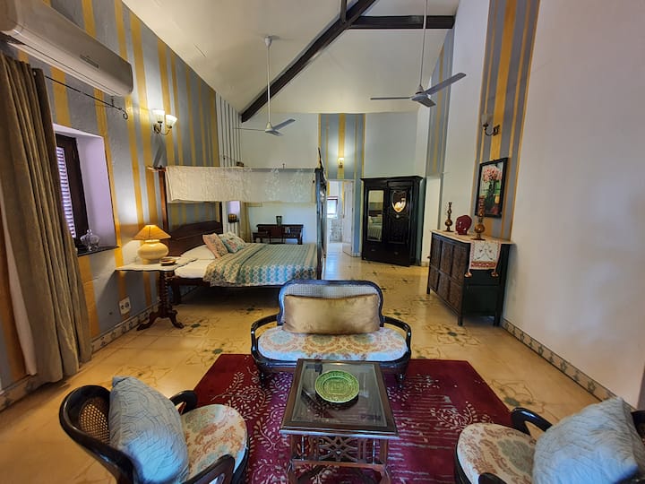 A spacious, vintage-inspired bedroom and living area, perfect for unwinding. With high ceilings and elegant decor, this space provides a luxurious and comfortable stay at our 6BHK Luxury Villa in Goa.