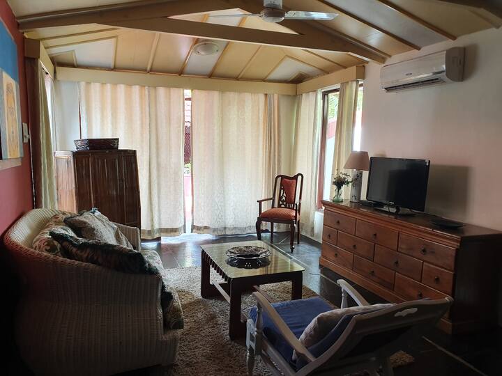 Relax in the cosy living area of our Luxury Villa in Goa. This comfortable space, featuring plush sofas and a TV, is perfect for unwinding after a day of exploring the beach and local sights.