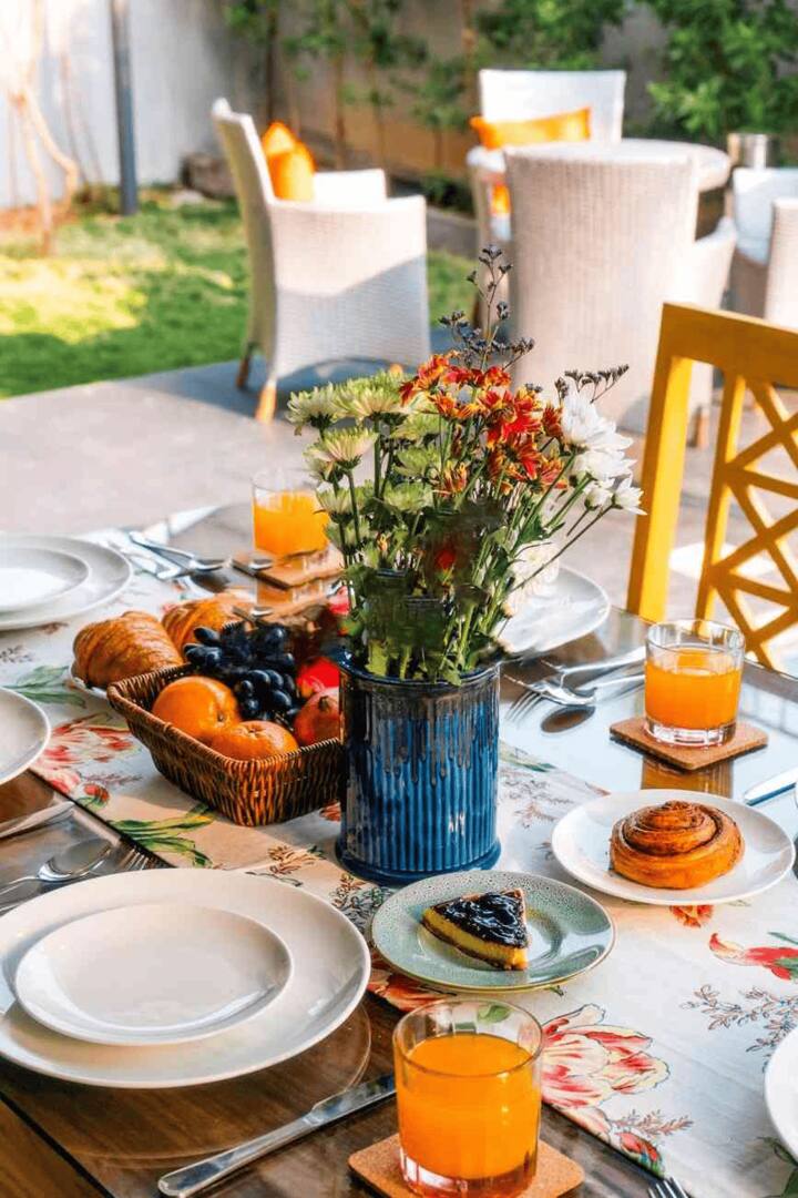 Enjoy al-fresco dining with a delicious spread amidst lush greenery at our Goa villa. Perfect for memorable meals with loved ones!