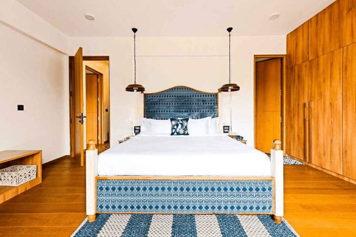 Discover another cosy bedroom in our Goa villa, featuring a unique blue and white patterned bed, ample storage, and stylish lighting for a restful stay.