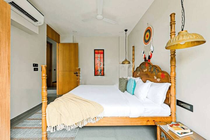 Relax in this uniquely designed bedroom at our Goa villa, featuring a distinctive four-poster bed and cosy ambiance for a peaceful night's sleep.