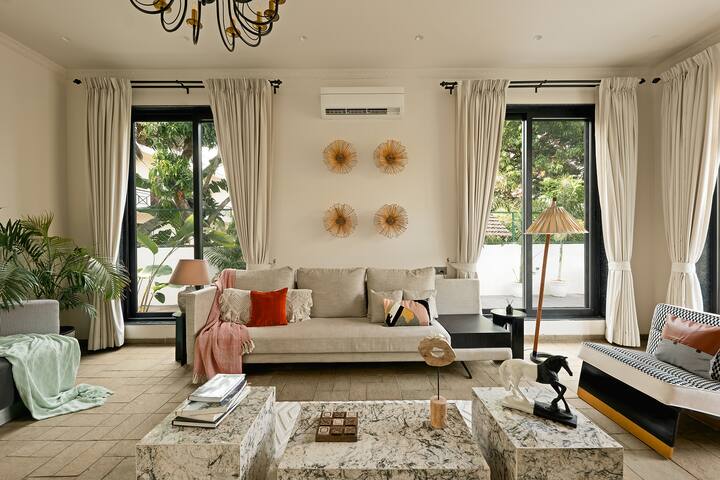 This elegant Goa villa features a bright living room with stylish décor, ample natural light, and comfortable seating, perfect for a relaxing getaway.