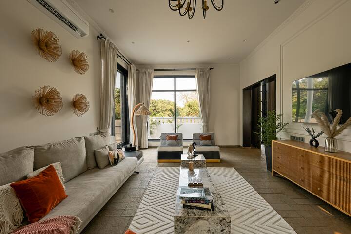 Elegant Goa villa living room: plush seating, artistic décor, and natural light. Your perfect serene escape awaits.