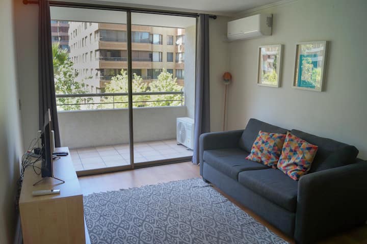 明亮的客厅，配备沙发、靠垫和智能电视。 空调冷/暖、高速无线网络和阳台。 墙上装饰有艺术品，非常适合放松身心