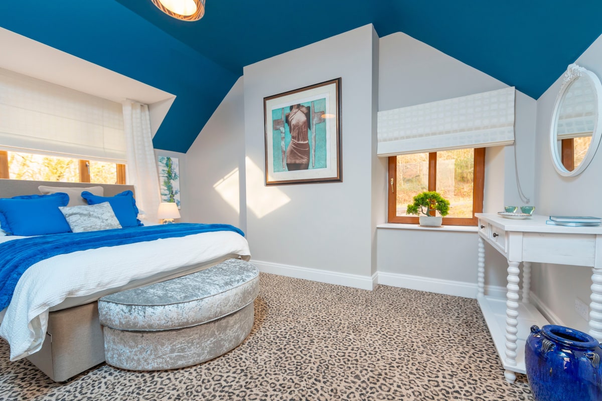 חדר השינה 'הנשי' שלנו עם יצירות אמנות יצירתיות, שטיח הדפס נמר ונופים במורד ההר.