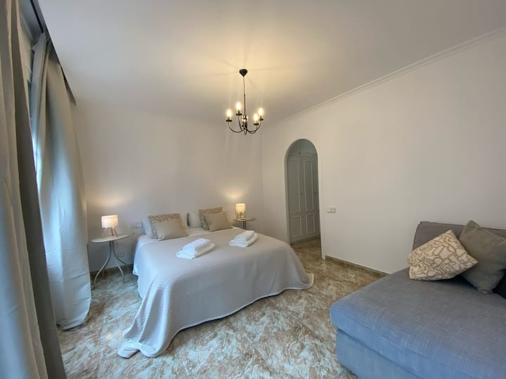 Habitación doble con baño completo y vestidor. Chaise-longe para relajarse y tener vistas a la calle principal.