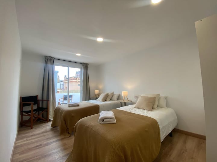 Habitación con dos camas individuales y terraza.