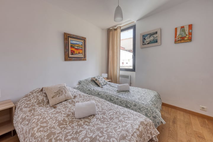 חדר שינה עם 2 מיטות יחיד עם חדר הלבשה מובנה וחלון ללא פנים