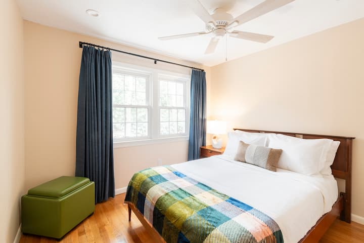 Një krevat me madhësi të plotë me perde që errësojnë dhomën krijon një vend të rehatshëm për të fjetur.