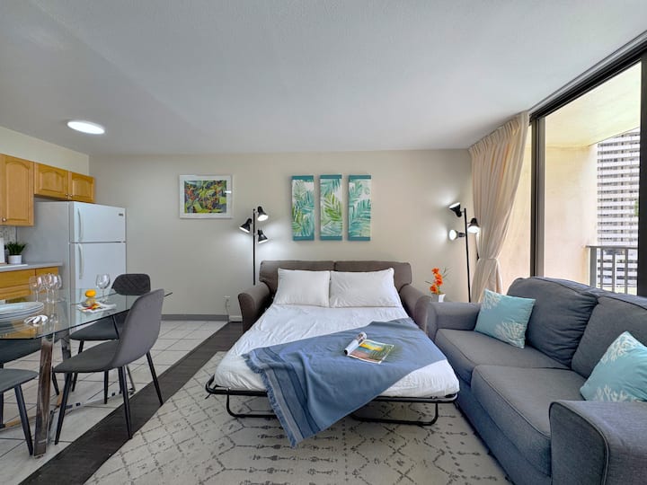 Funkcionalan dnevni boravak u kojem se nalazi kauč na razvlačenje koji se može upotrebljavati kao dodatni krevet, udoban kauč, moderan stakleni stol za blagovanje i praktična kuhinja.