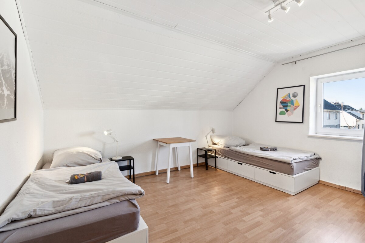 时尚的卧室，床边有柔和的灯光，大窗户自然采光充足，还有衣物存放空间，让您享受轻松舒适的住宿体验