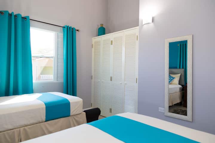 Con dos camas individuales, cada una acompañada de un banco de cama para descansar mientras te pones los zapatos. La ventana tiene vistas al patio delantero. Un espejo de cuerpo entero, la cómoda ofrece espacio para prepararse para un día en la playa o una noche en la ciudad.