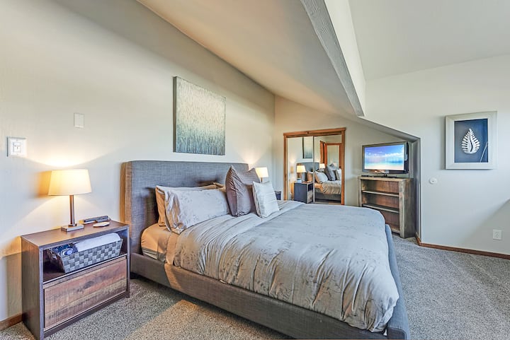 Chumba cha kulala cha ghorofa ya juu chenye nafasi kubwa, kilicho na kiti cha dirisha chenye mandhari ya kupendeza. Ukiwa kwenye starehe ya kitanda chako, furahia mandhari tulivu ambayo huboresha ukaaji wako kwa uzuri wa asili.