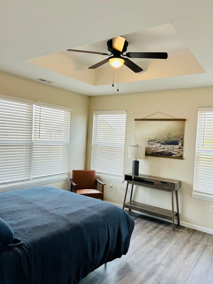 Un dormitorio principal sencillo y cómodo con una cama de tamaño completo.