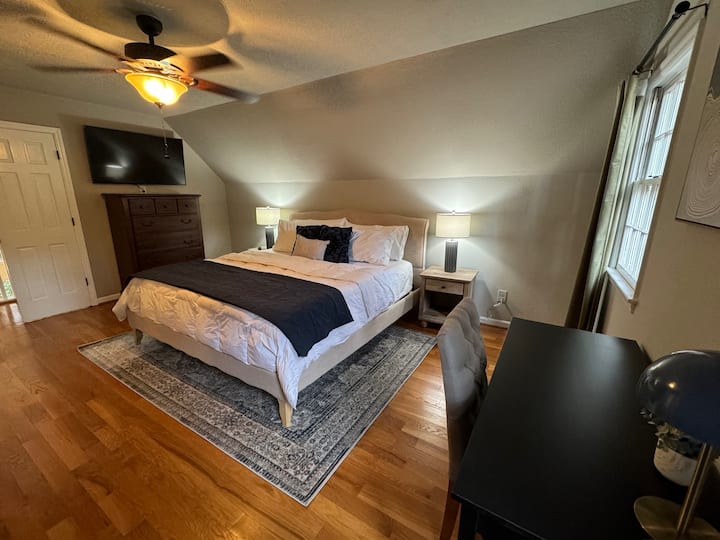 Chumba cha kulala cha msingi kilicho kwenye ghorofa ya 3 ya nyumba, chenye bafu na sehemu ya kazi iliyoambatishwa. 