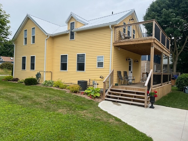 A charming yellow house is depicted, featuring a spacious deck with four chairs and steps leading to a well-maintained lawn. The exterior showcases neatly trimmed landscaping, and large windows allow natural light to fill the interior.