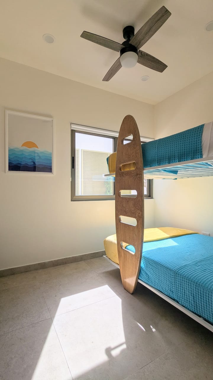 Habitación con literas con dos camas tamaño completo como litera y gabinetes de almacenamiento de ropa separados.