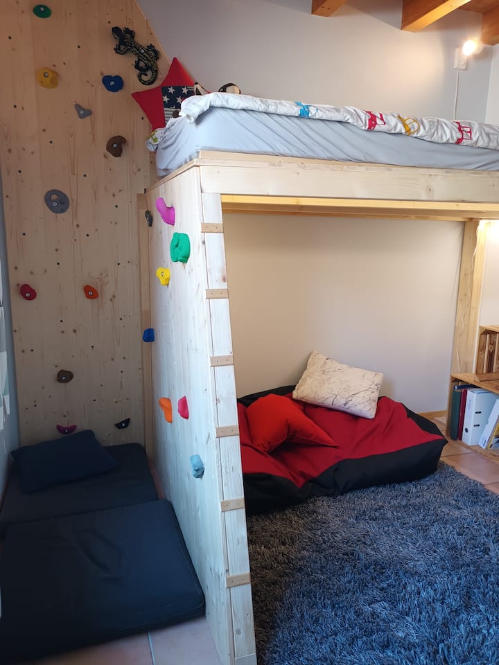 The bed is high without a barrier and for a climb it is a small climbing wall. It's possible to add a mattress to the floor.
The bedroom is on the ground floor.