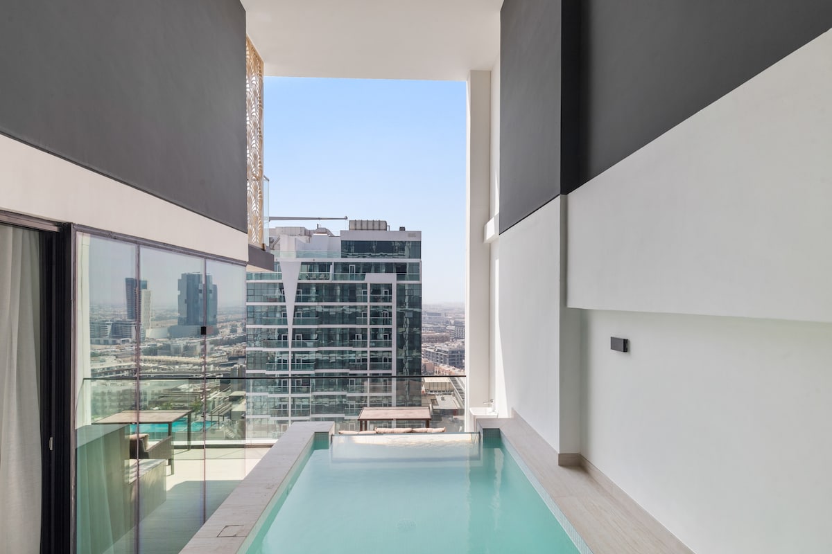 A tranquil private pool is shown on the balcony, extending from the modern apartment on the 17th floor. Large glass doors provide a view of the city below, creating a seamless connection between indoor and outdoor spaces.