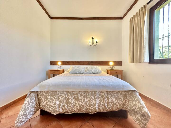 Spavaća soba s prozorom koji nudi prekrasan pogled na prirodu i ocean, ispunjena prirodnim svjetlom za miran i opuštajući boravak!