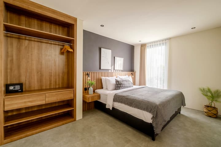 Svit sovrum med en dubbelsäng, rymligt garderobsområde och ett privat badrum — beläget på bottenvåningen.