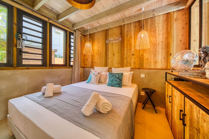 Lit queen size dans un espace cocooning intimiste, chaleureux, idéal pour se reposer en toute tranquillité à l’Oasis des Colibris sur l’Étang-Salé.
