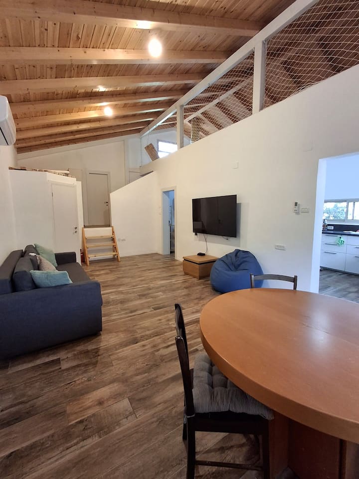 A living room that includes a pleasant and spacious sofa that can also open to a double bed, a dining table and chairs, opens to 10 people, TV, internet, a closet with games and books. Air conditioning and a window for natural lighting.