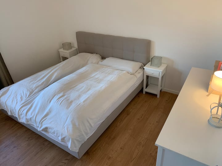 เตียงคู่พร้อมโต๊ะข้างเตียง ลิ้นชัก ม่านและบานเกล็ด ม่านกันแมลง ตู้เสื้อผ้า (ประตูบานเลื่อน ราวแขวนเสื้อผ้า ลิ้นชัก ชั้นวางของ ฯลฯ) พร้อมเก้าอี้อ่านหนังสือ