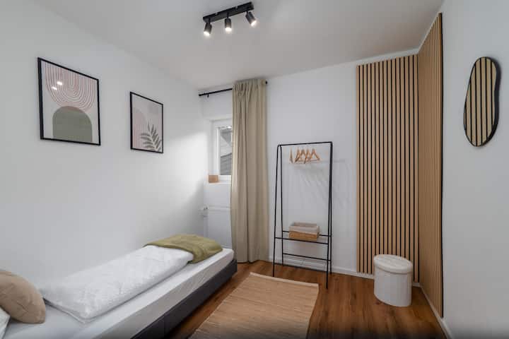 El tercer dormitorio con sábanas preparadas del hotel está en el piso superior, un piso más alto y justo al lado del baño. Aquí también, la habitación se puede oscurecer y hay suficiente espacio para tus maletas y maletas de viaje.
