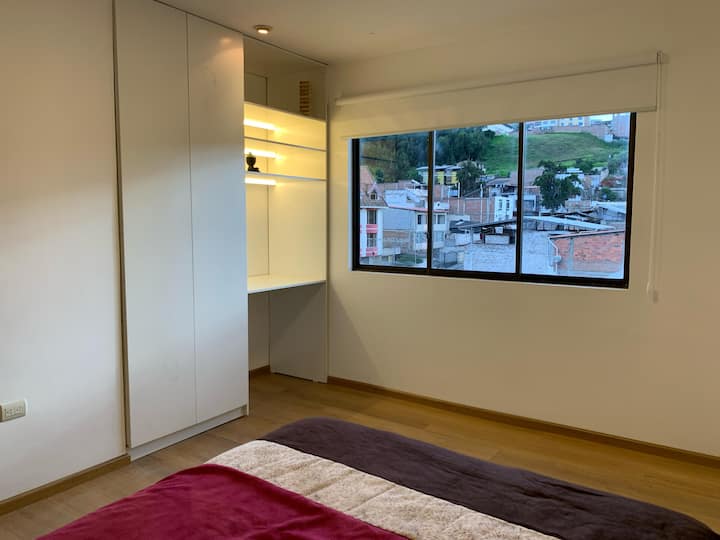 Zgjohu nga drita natyrale dhe pamjet e qytetit. Krevat i rehatshëm me tone të ngrohta. Gardërobë e madhe e bardhë me një tavolinë pune të ndriçuar. Dyshemeja e lehtë prej druri dhe muret e bardha krijojnë një mjedis modern dhe të qetë. Ideale për pushimet dhe kënaqësinë tënde!