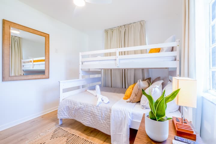 בחדר הזה יש מיטת קומתיים זוגית, מושלמת לסידורי שינה גמישים או למשפחות. וילונות האפלה, מראה בוהו גדולה וצמח נחש לשפע של חמצן. מנורת השולחן כוללת יציאות מיזוג אוויר, USB ו - USB - C לטעינה