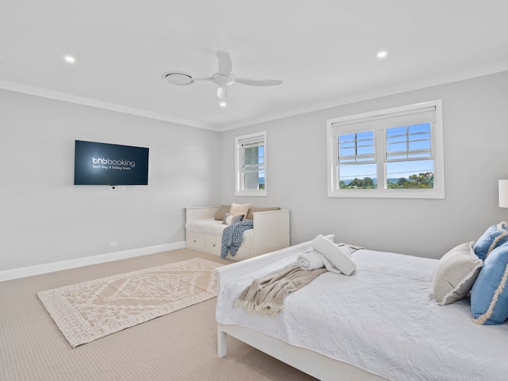 Camera con letto matrimoniale, TV e ventilatore a soffitto.