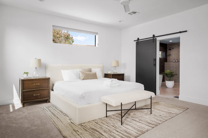 Wake up refreshed in this modern master suite, complete with a cozy upholstered bed, stylish décor, and private bathroom access. It’s a calm and peaceful space designed with comfort in mind.