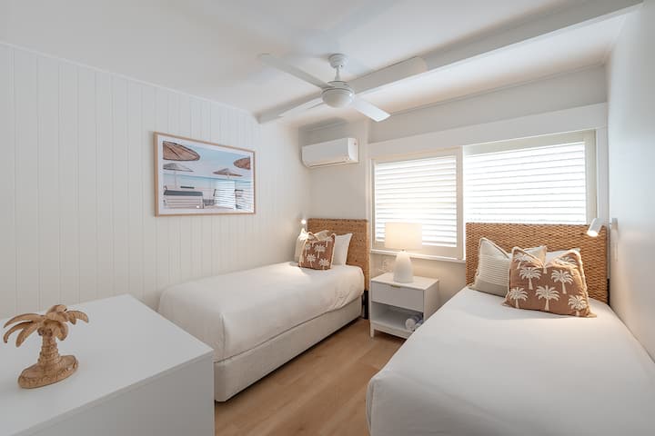 Dva jednostruka kreveta s klima-uređajem, ventilatorom i svjetiljkom.