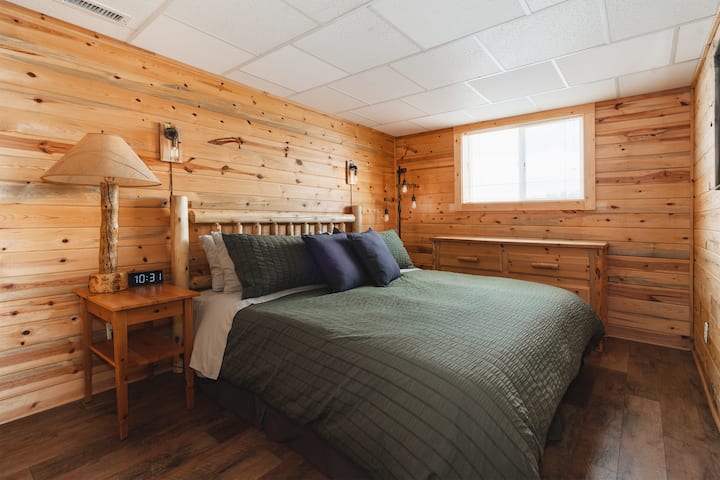 סוויטת חדר שינה בקומת קרקע עם מיטת נקטר קינג מפוארת לנוחות ומנוחה.